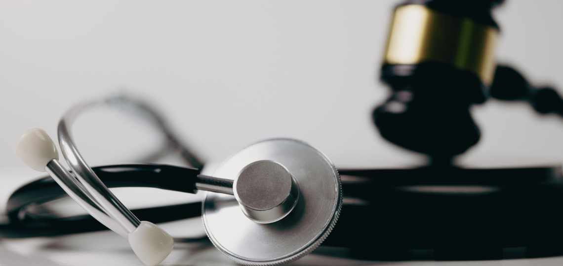 Stethoscope and gavel on white background, symbol of law and medic