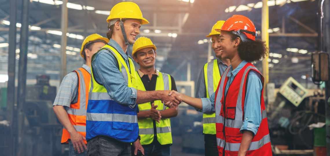 A group of industry workers and engineers of various races enjoy working in a heavy plant and stand together with a pleasant smile. portrait