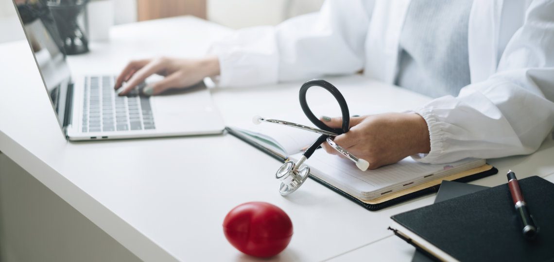 Portrait of doctor smiling wearing eyeglasses and showing stethoscope tools at office in private clinic. Medicine and health care and insurance concept